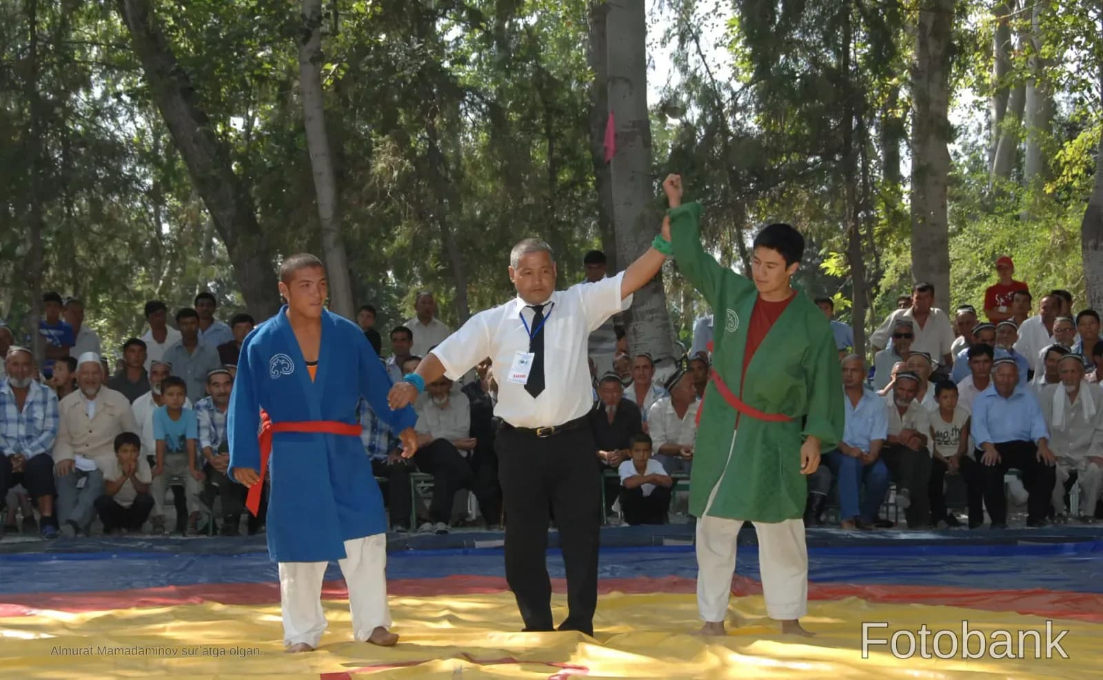 Referee raising the hand of a wrestling winner during a competition