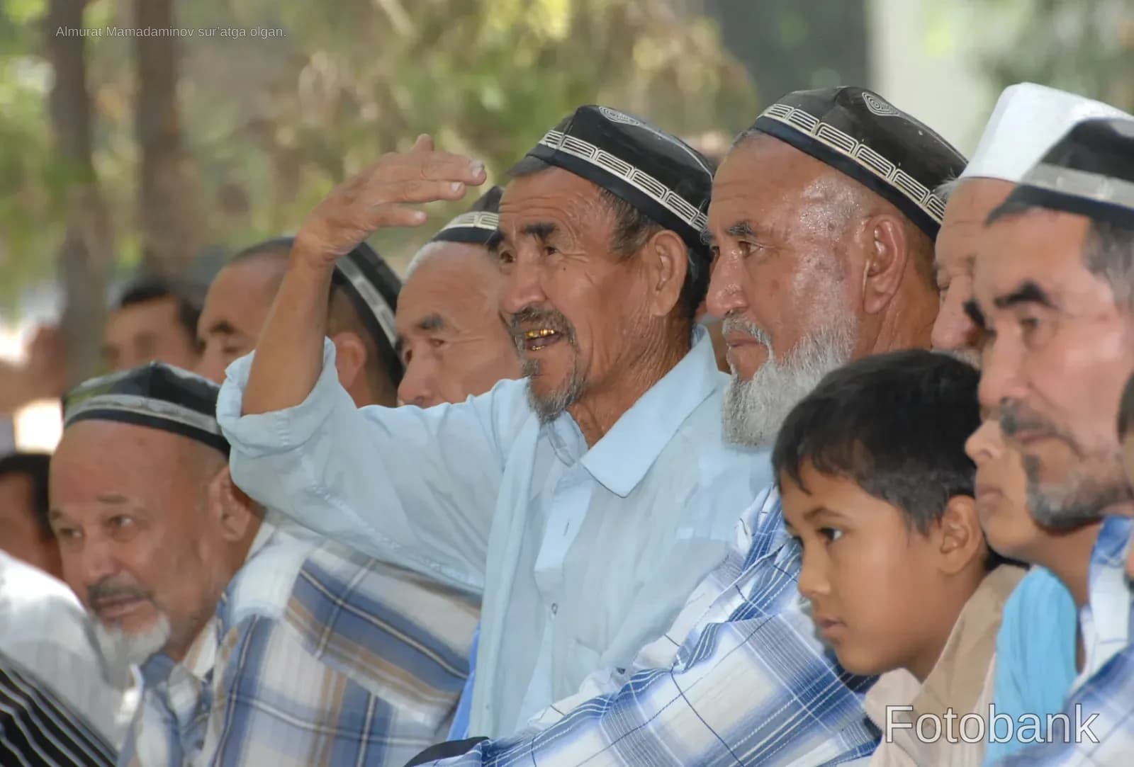 Group of senior men in traditional headwear gathering outdoors
