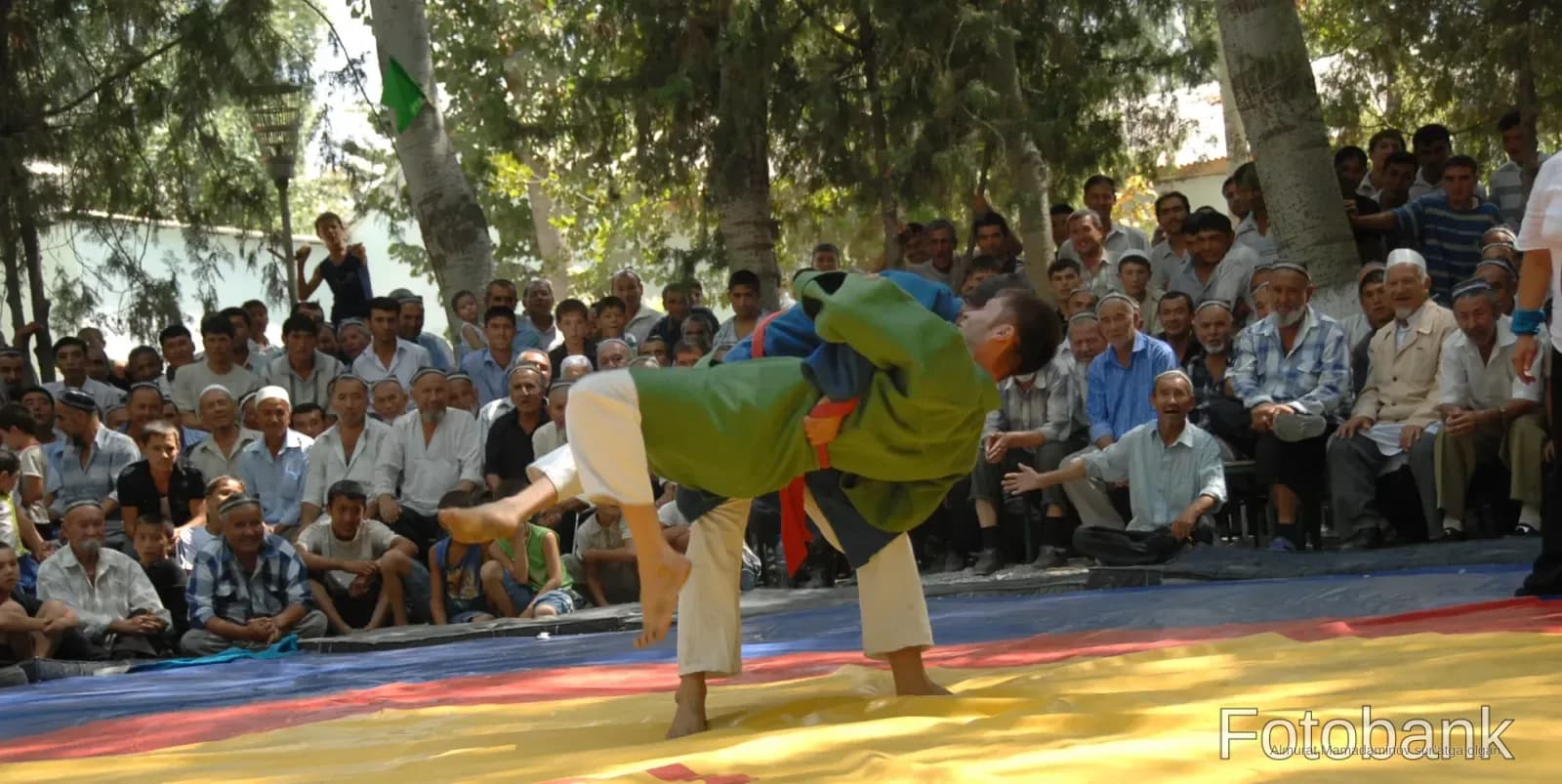 Wrestlers competing on a mat outdoors