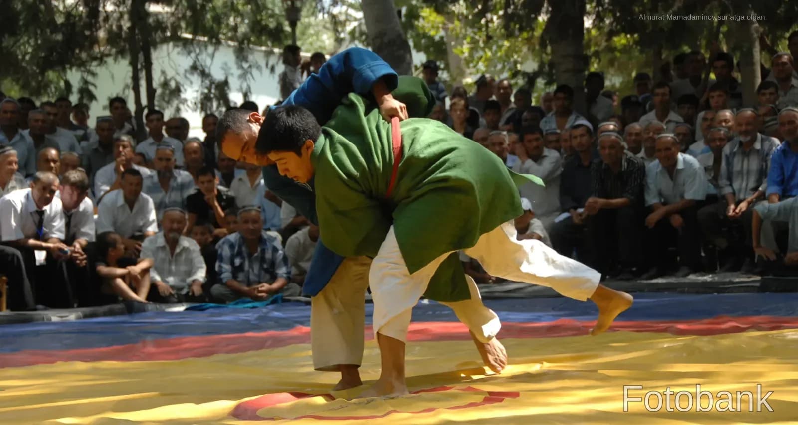 Athletes competing in a wrestling match outdoors