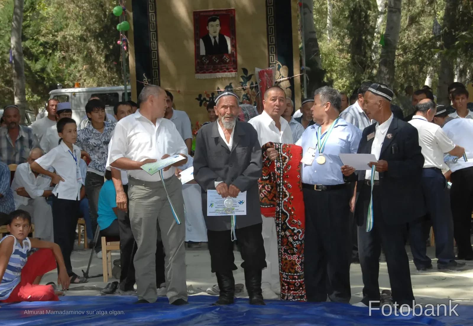 Group of people gathered outdoors holding certificates and medals