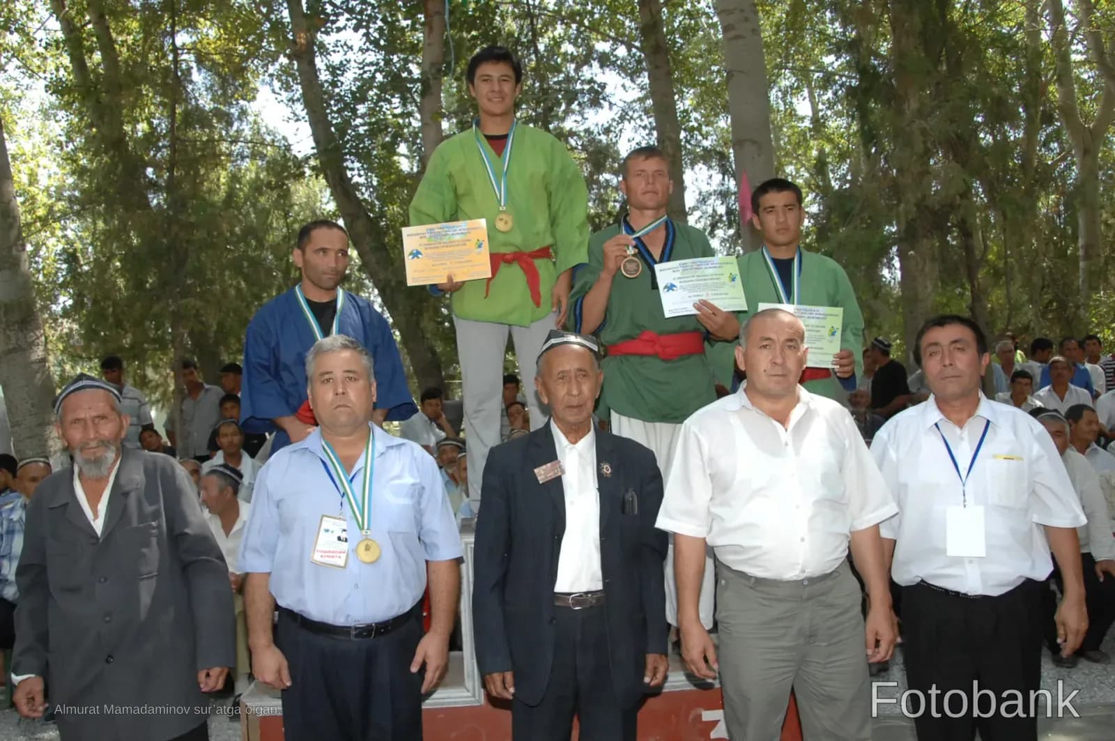 Athletes standing on a podium with medals and certificates