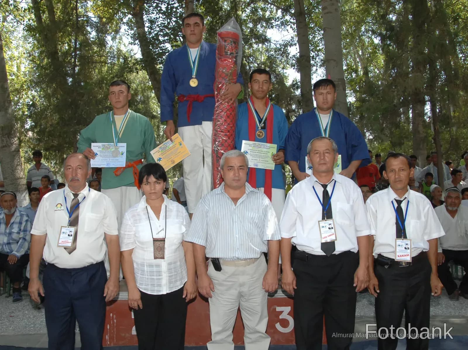 Athletes and officials posing at a sports competition ceremony