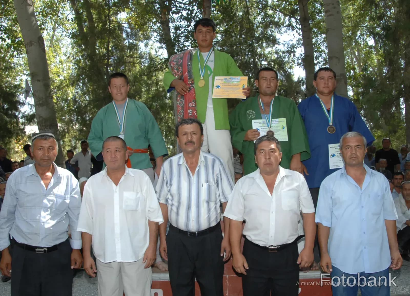 Athletes and officials posing at an outdoor sports competition ceremony