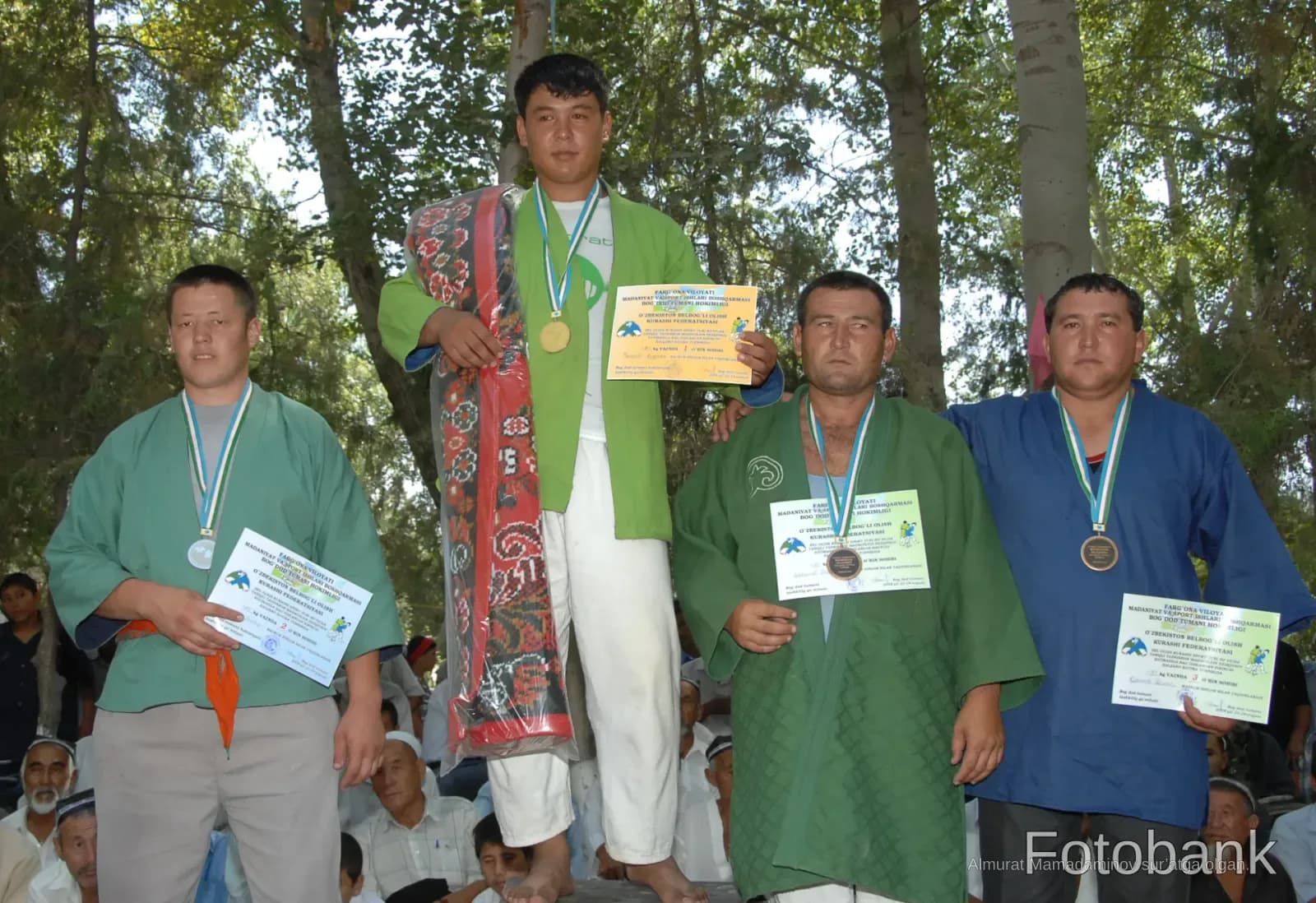Athletes holding certificates and medals outdoors