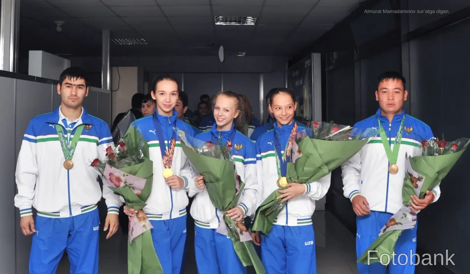 Спортсмены в спортивной одежде с медалями и букетами цветов