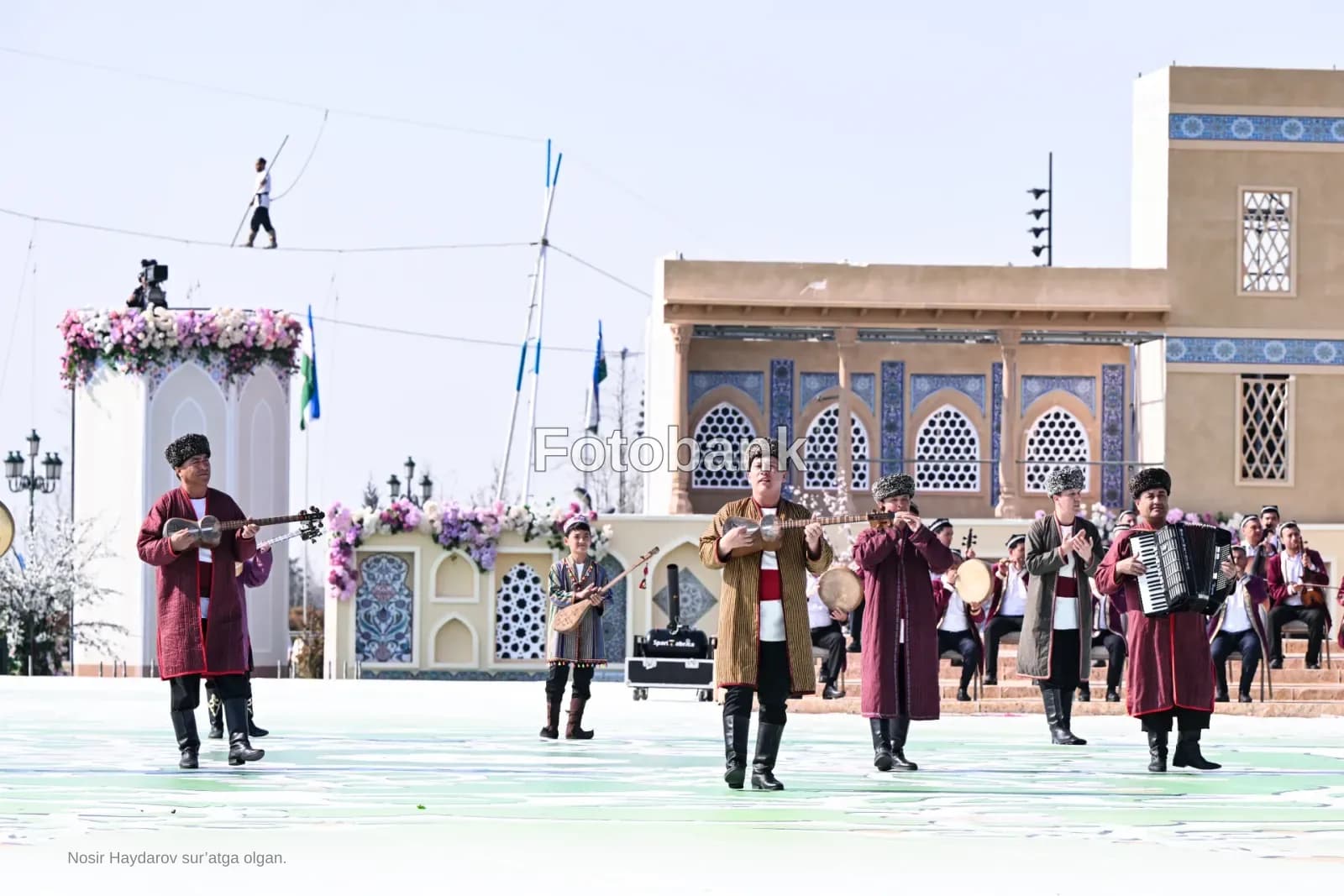 Performers in traditional clothing play musical instruments outdoors
