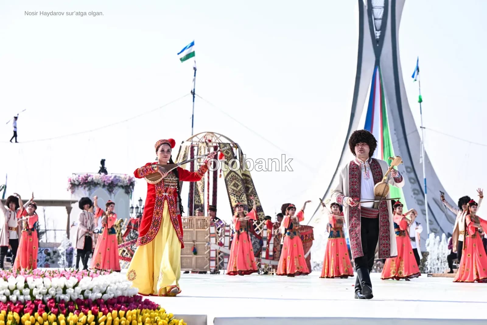 Performers in traditional clothing play stringed instruments outdoors