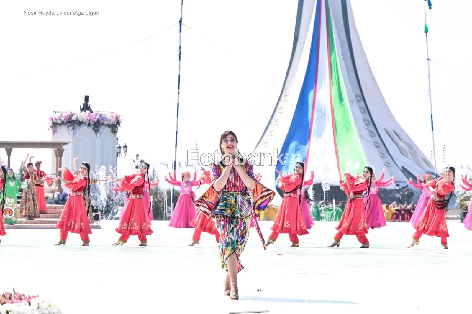 Performers in traditional attire dance outdoors