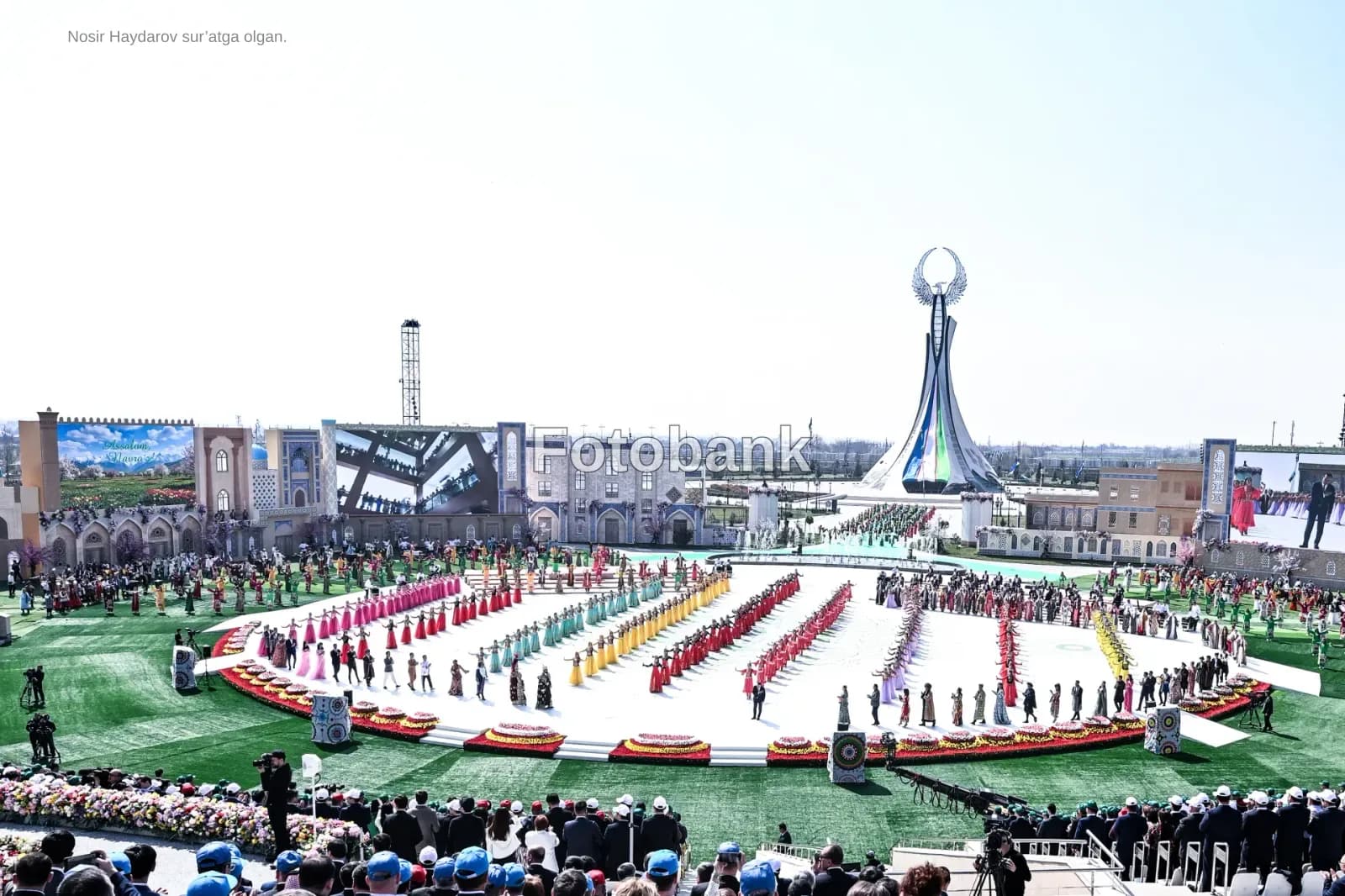 Performers in colorful costumes gather during a large-scale outdoor cultural festival