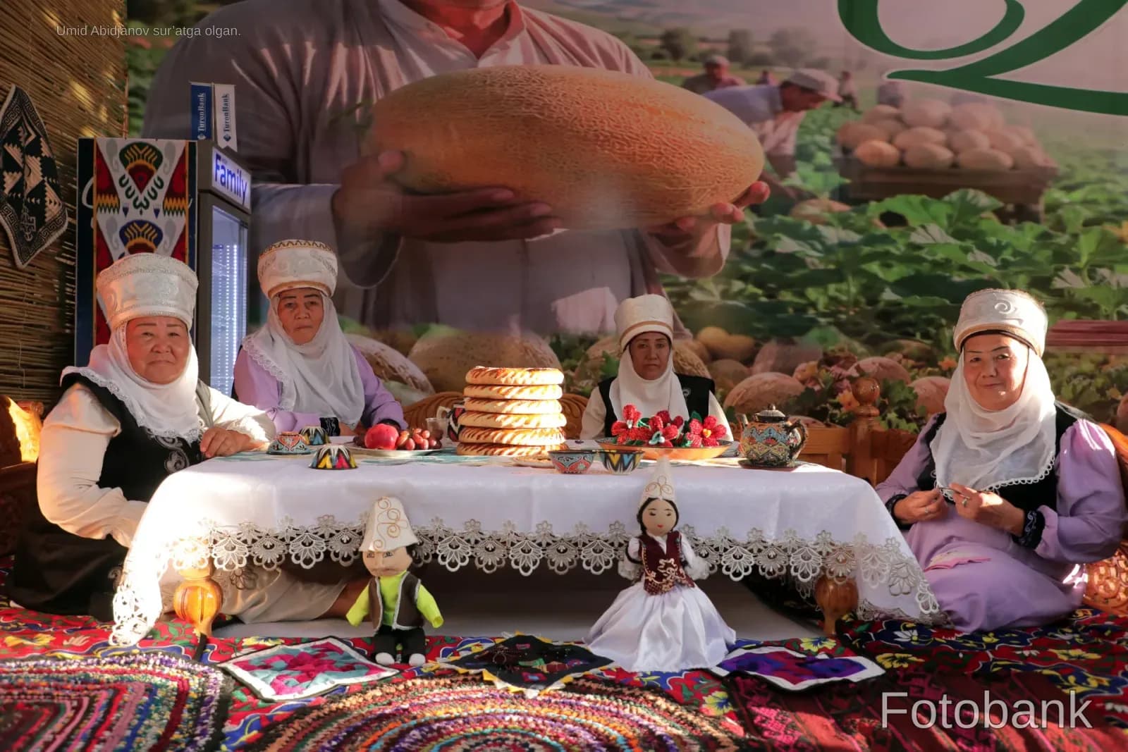 Women in traditional clothing sitting at a table with food