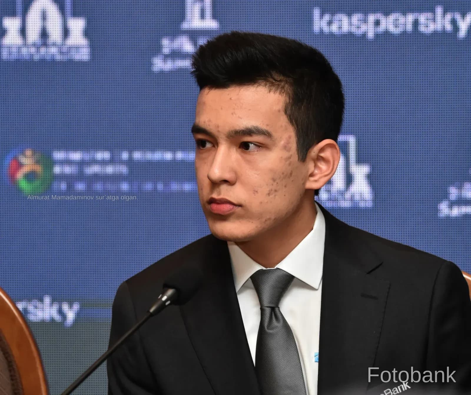 Young man in formal suit speaking at conference table