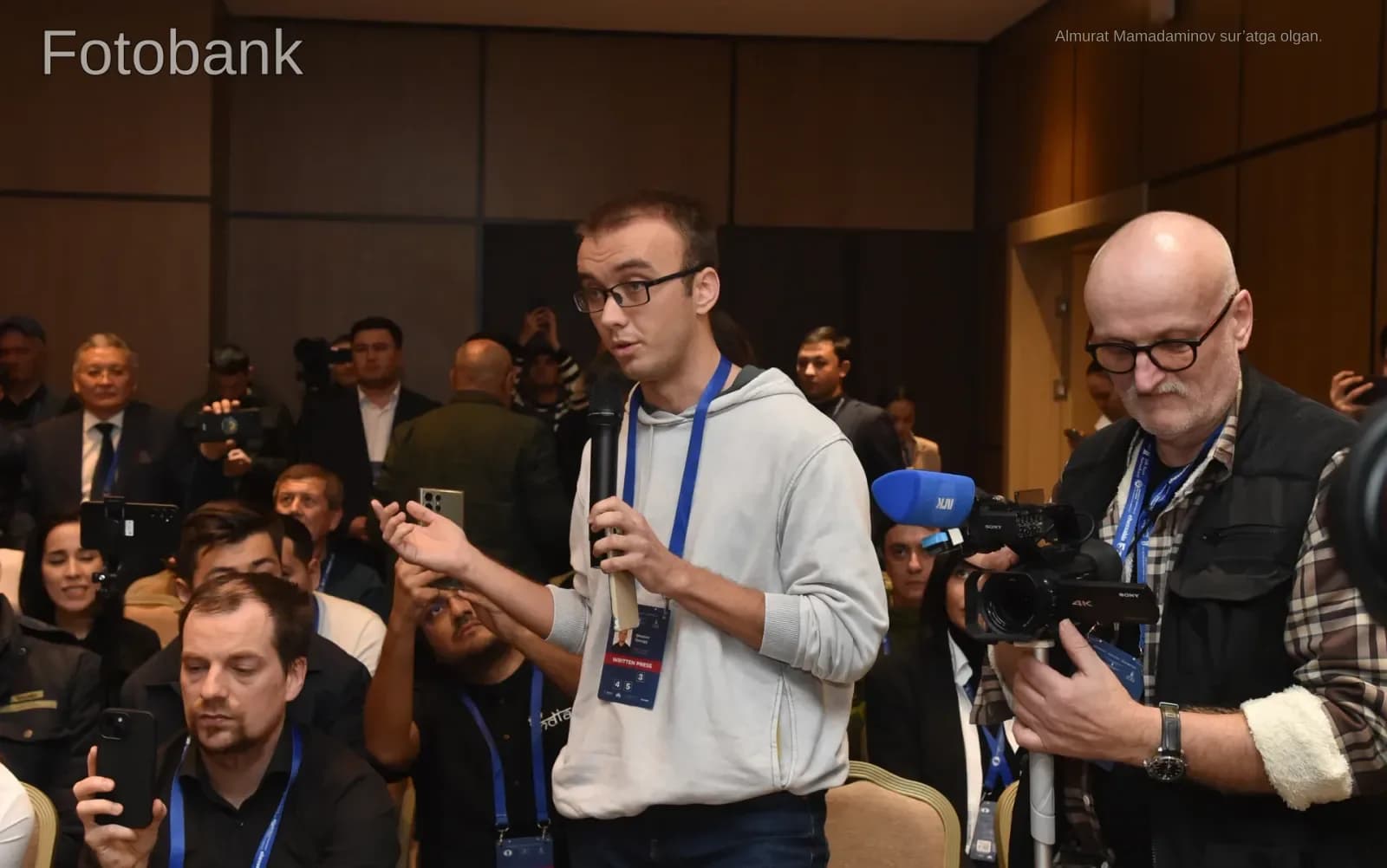Man speaking into a microphone during an indoor meeting