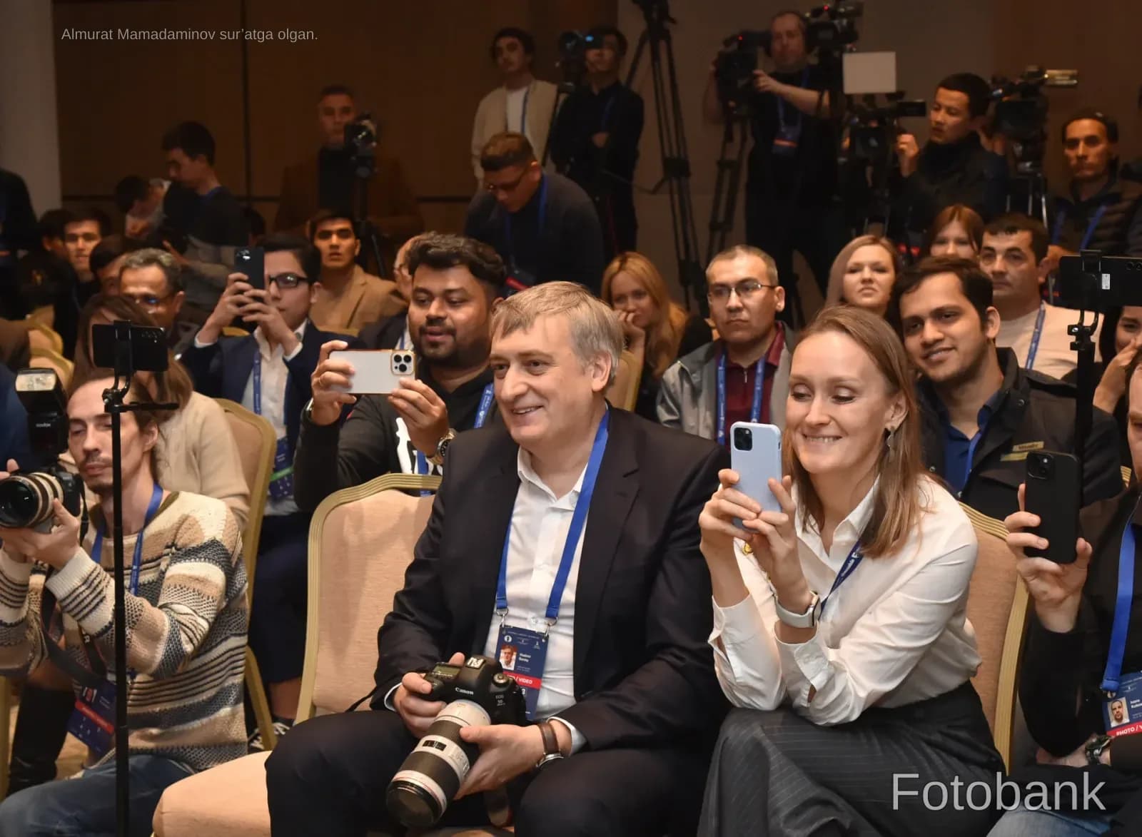 Люди, фотографирующие и снимающие видео с помощью камер и смартфонов в зале