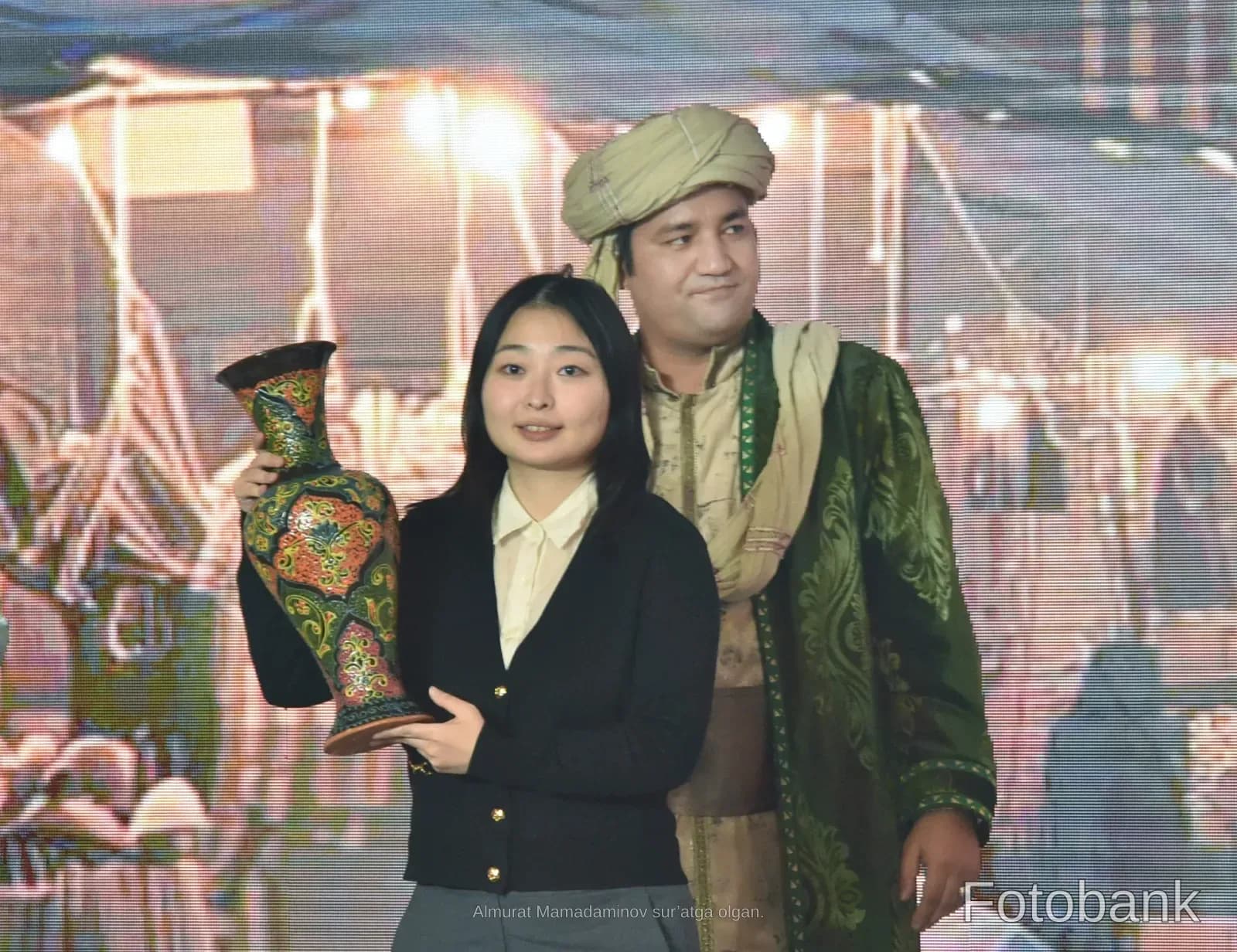 People posing with a decorative vase
