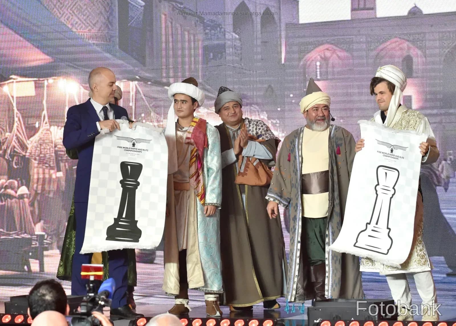 People holding banners with chess piece illustrations on stage