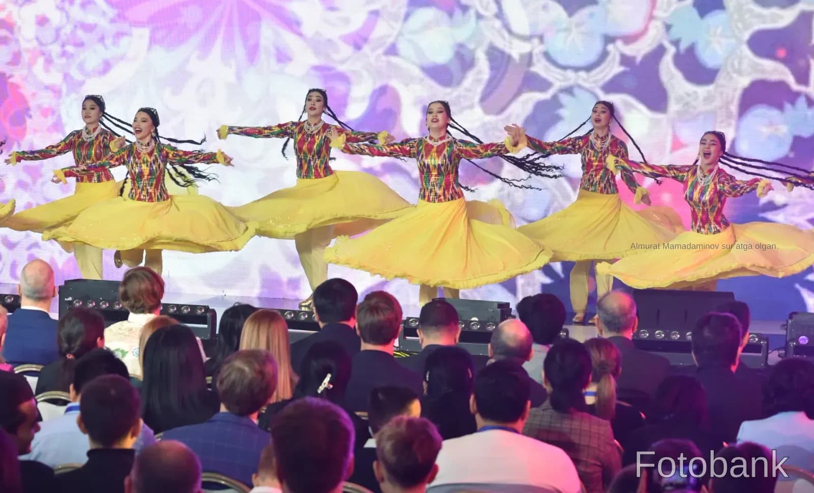 Performers in traditional colorful costumes dancing on a stage