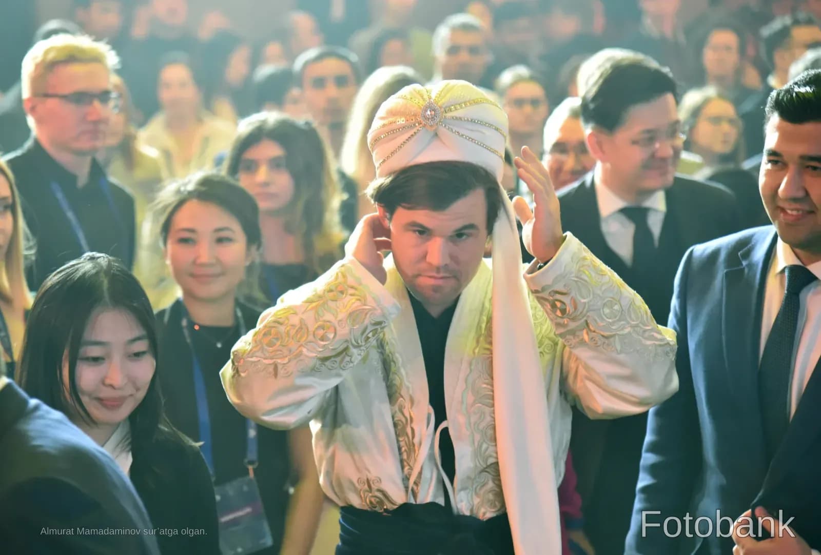 Man in traditional attire adjusting headwear