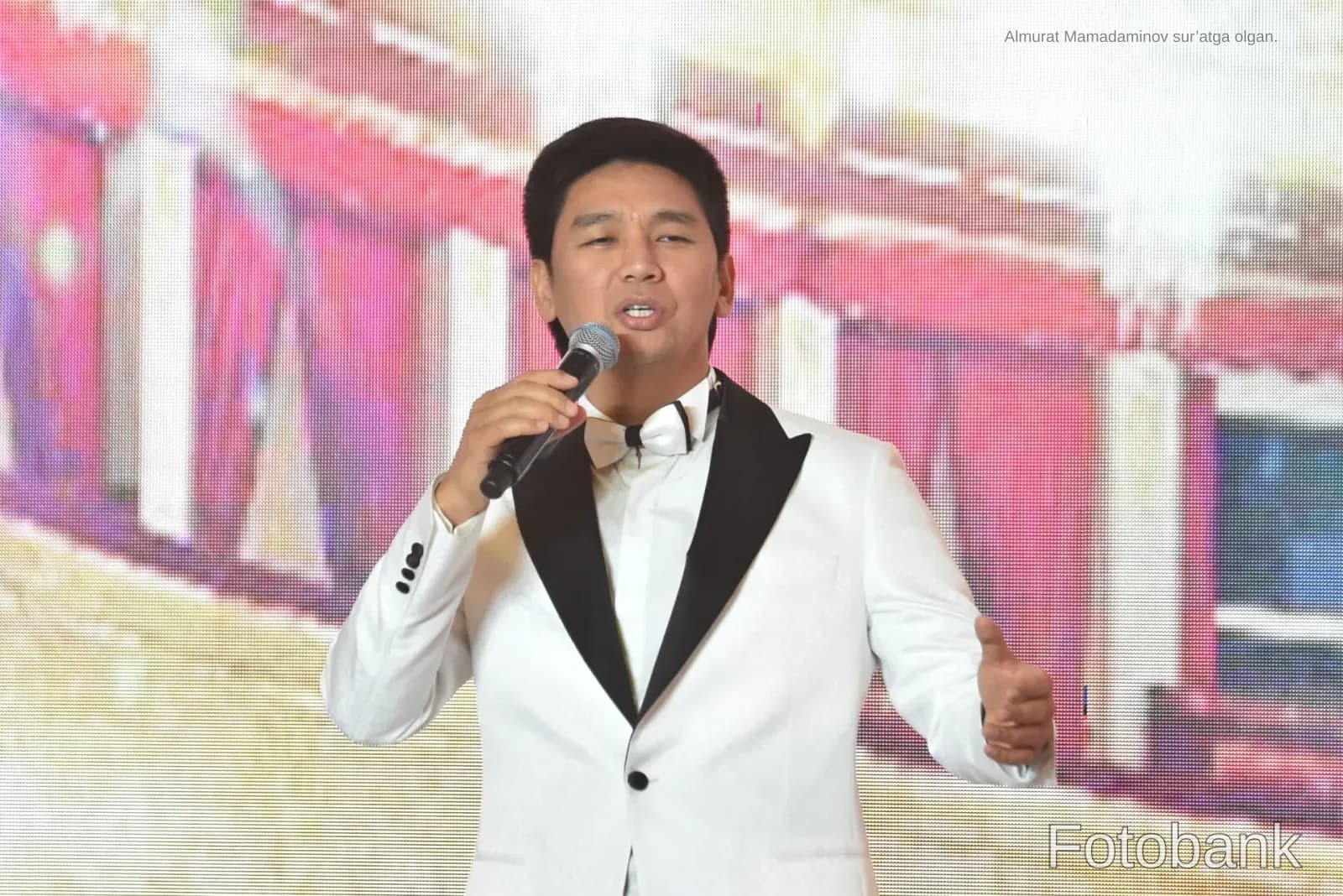 Person singing into a microphone on stage