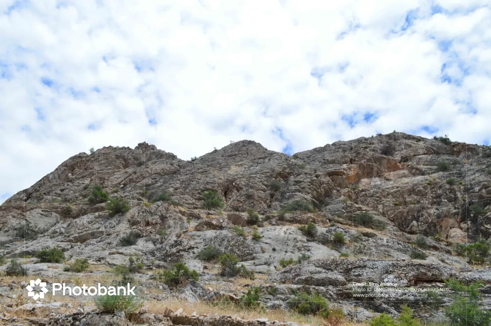 Rugged rocky mountain slope under a cloudy sky