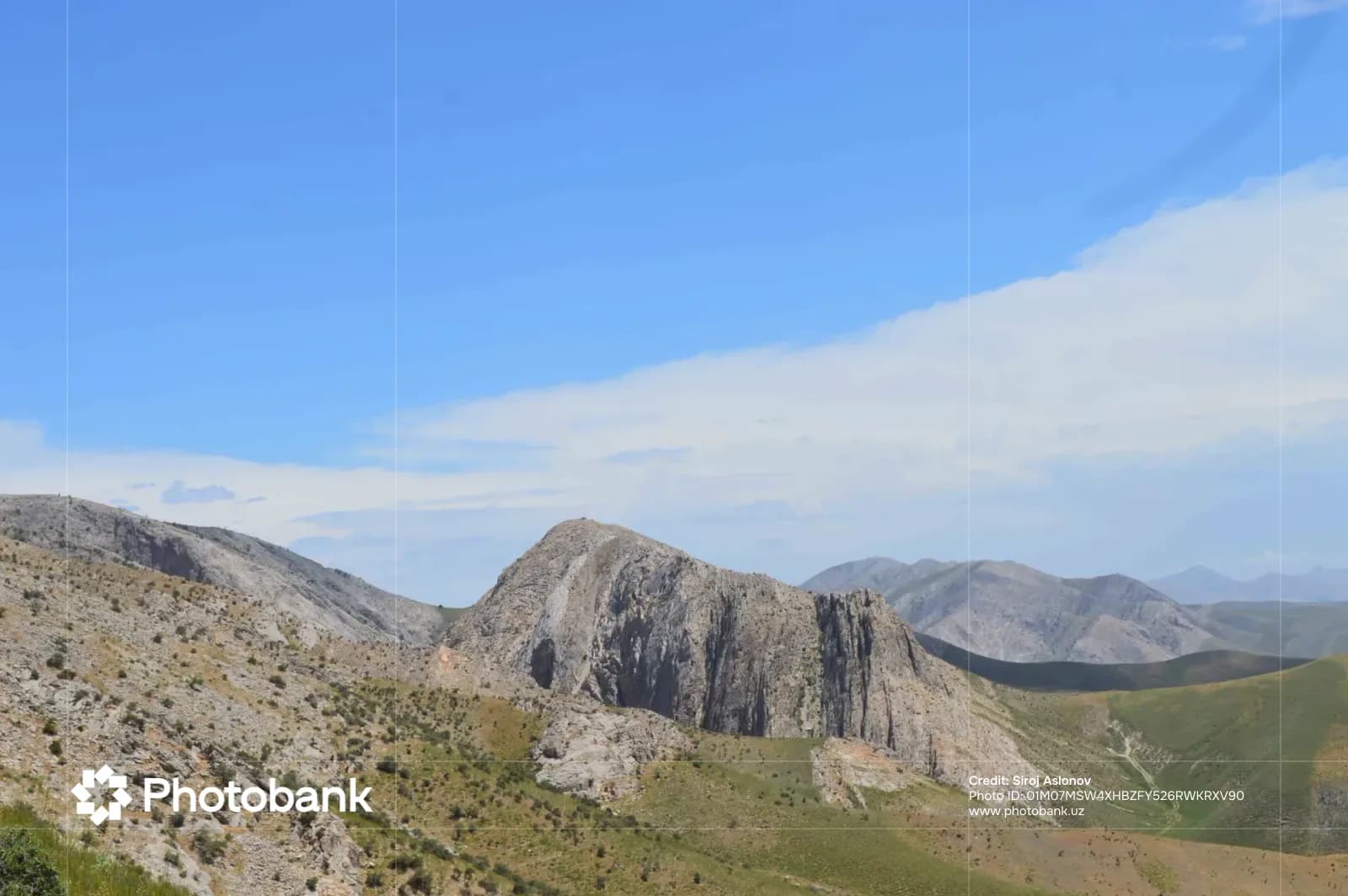 Mountain landscape under a cloudy blue sky