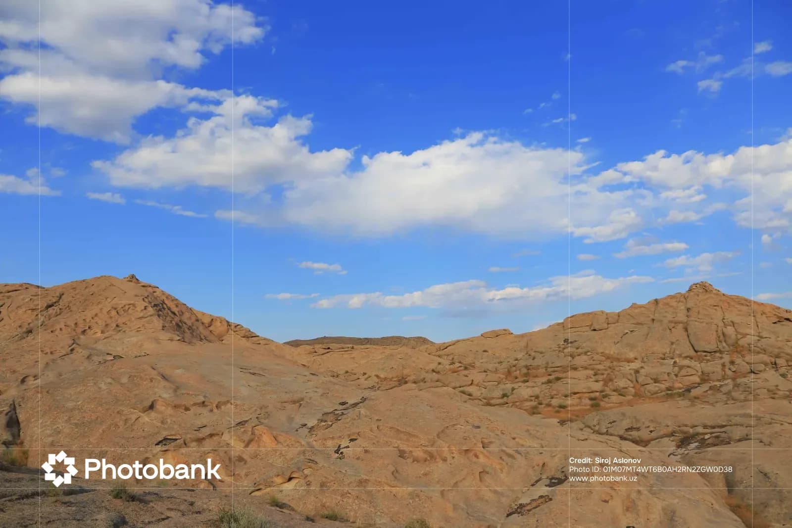 Rocky landscape under a blue sky with white clouds