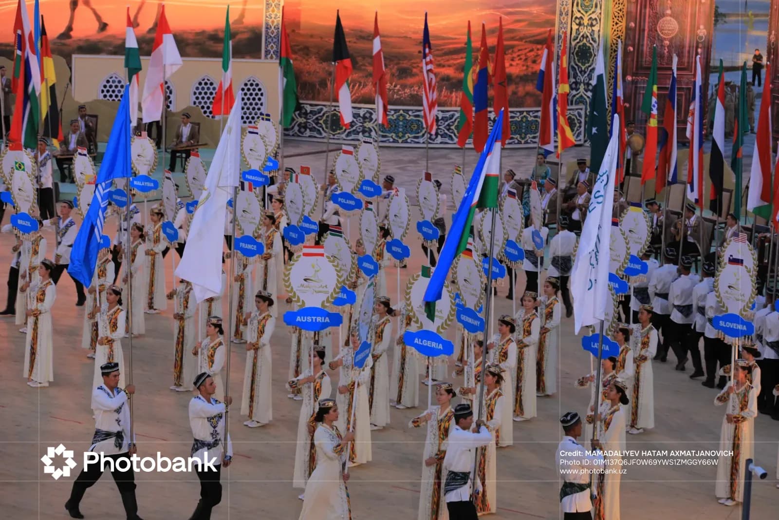 Xalqaro festivalda bayroq va plakatlar koʻtargan delegatsiyalar