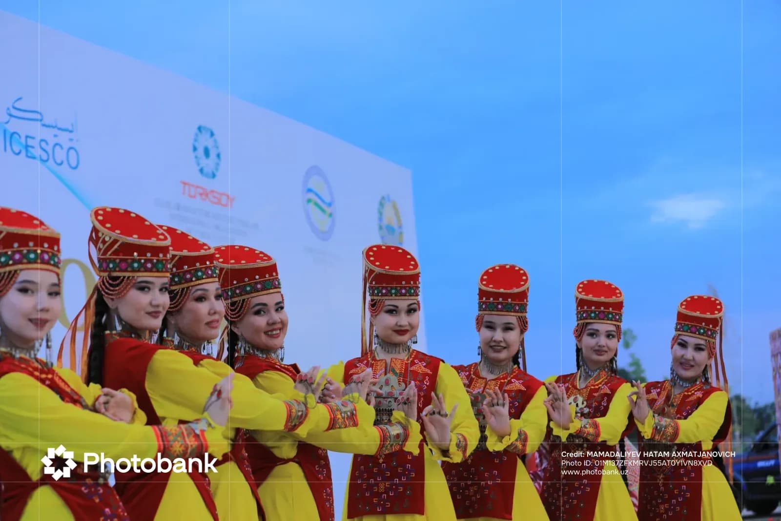 Performers in traditional attire and headdresses posing outdoors