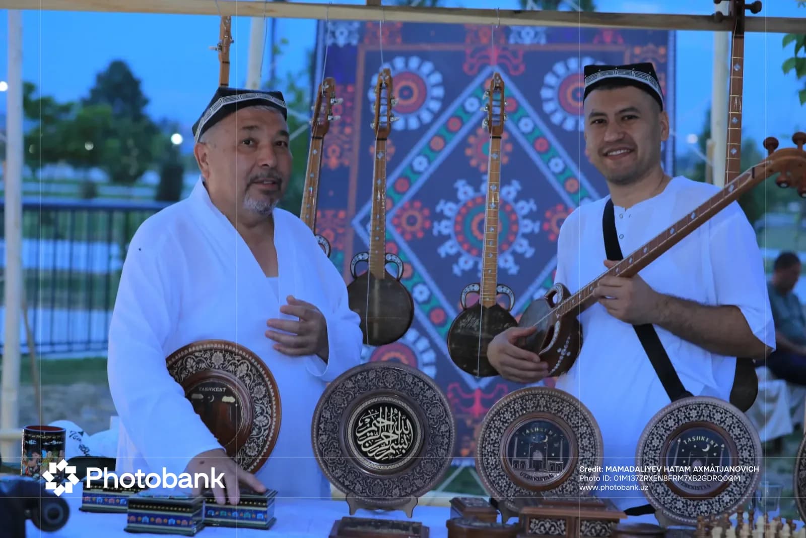 Men posing with traditional stringed instruments and decorated wooden plates