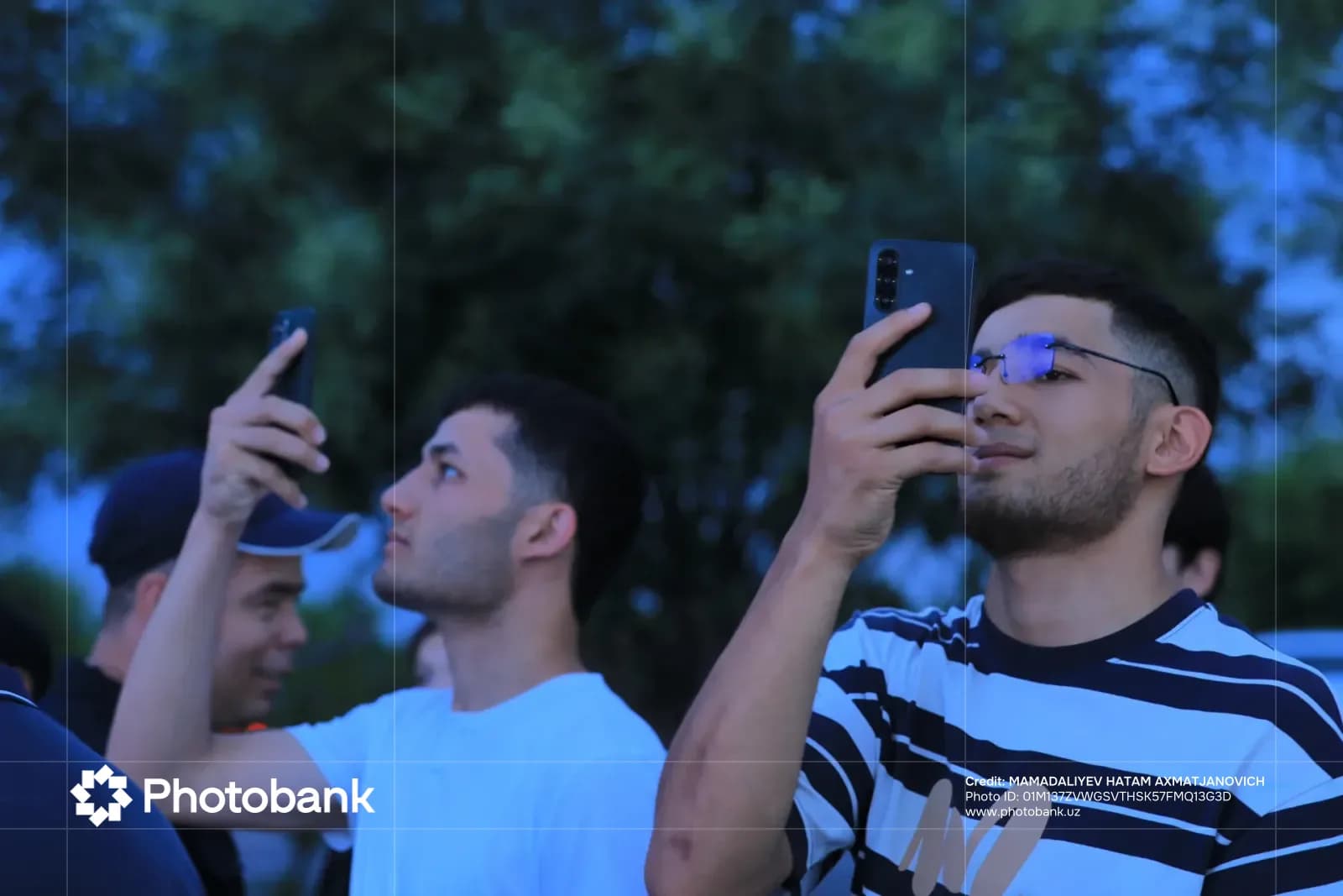People taking pictures with mobile phones outdoors