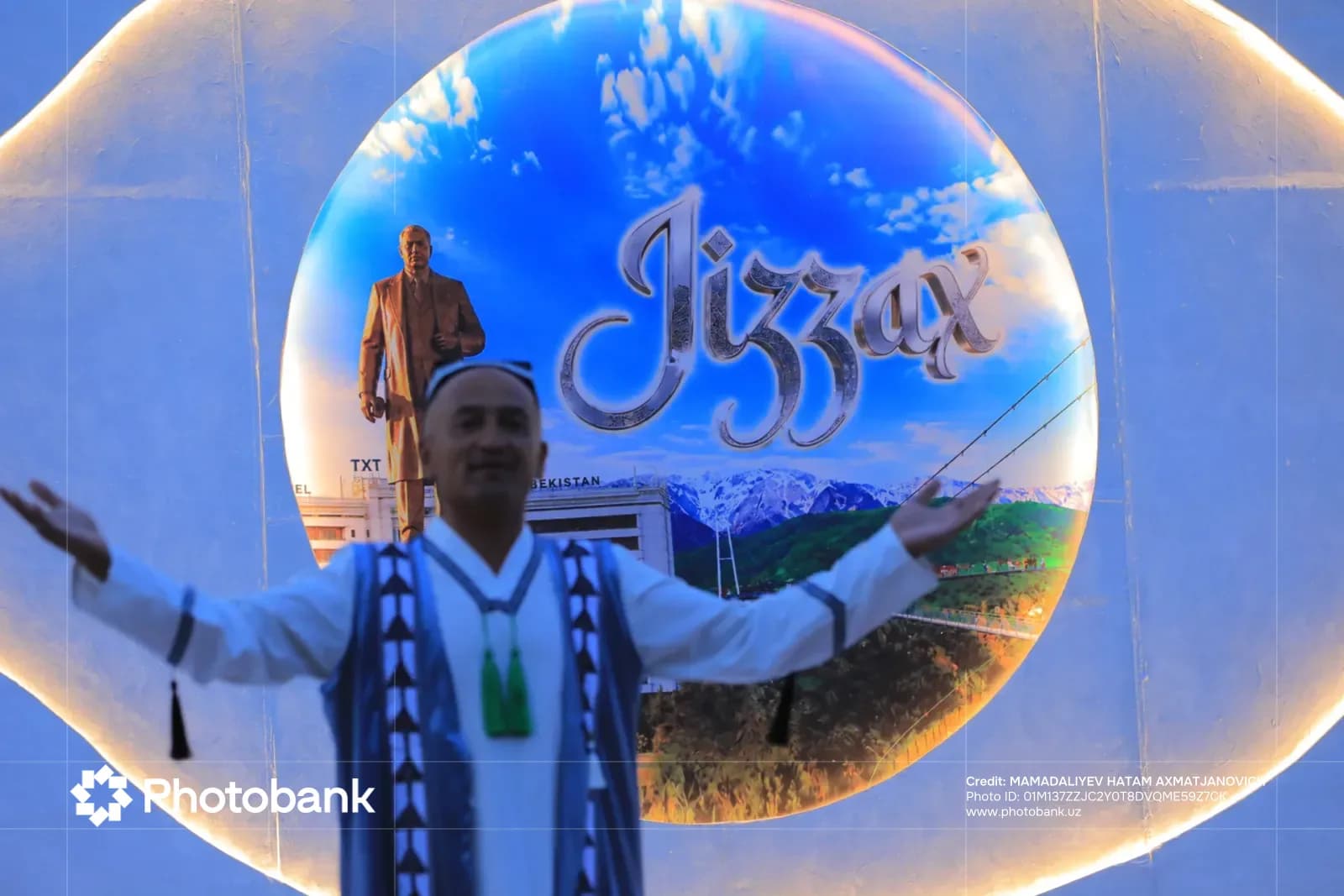 Person posing in front of a circular display with Jizzax text