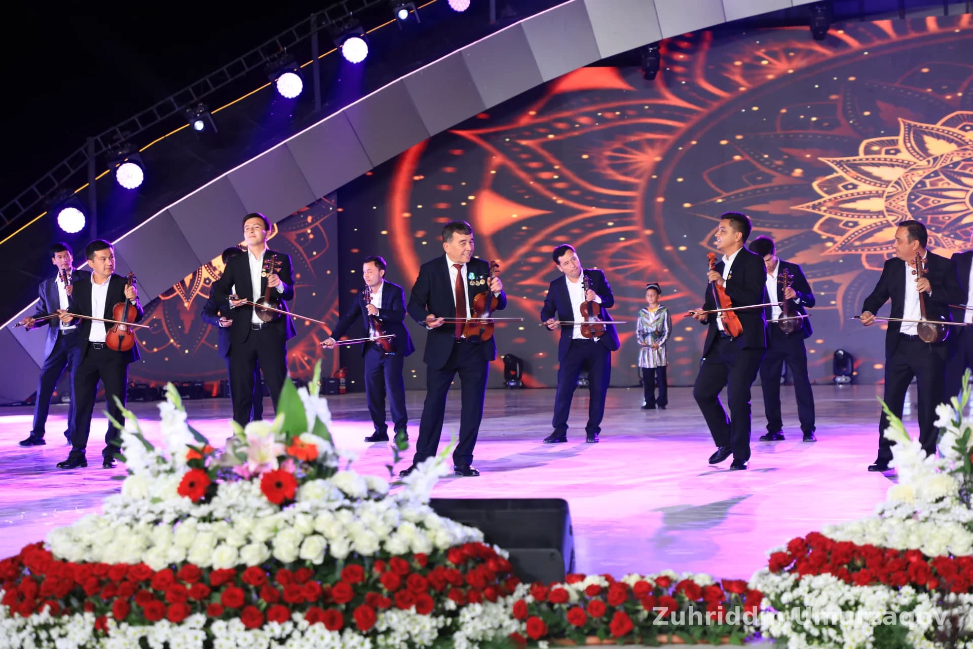 Sahnada musiqa ijro etayotgan bir guruh erkaklar