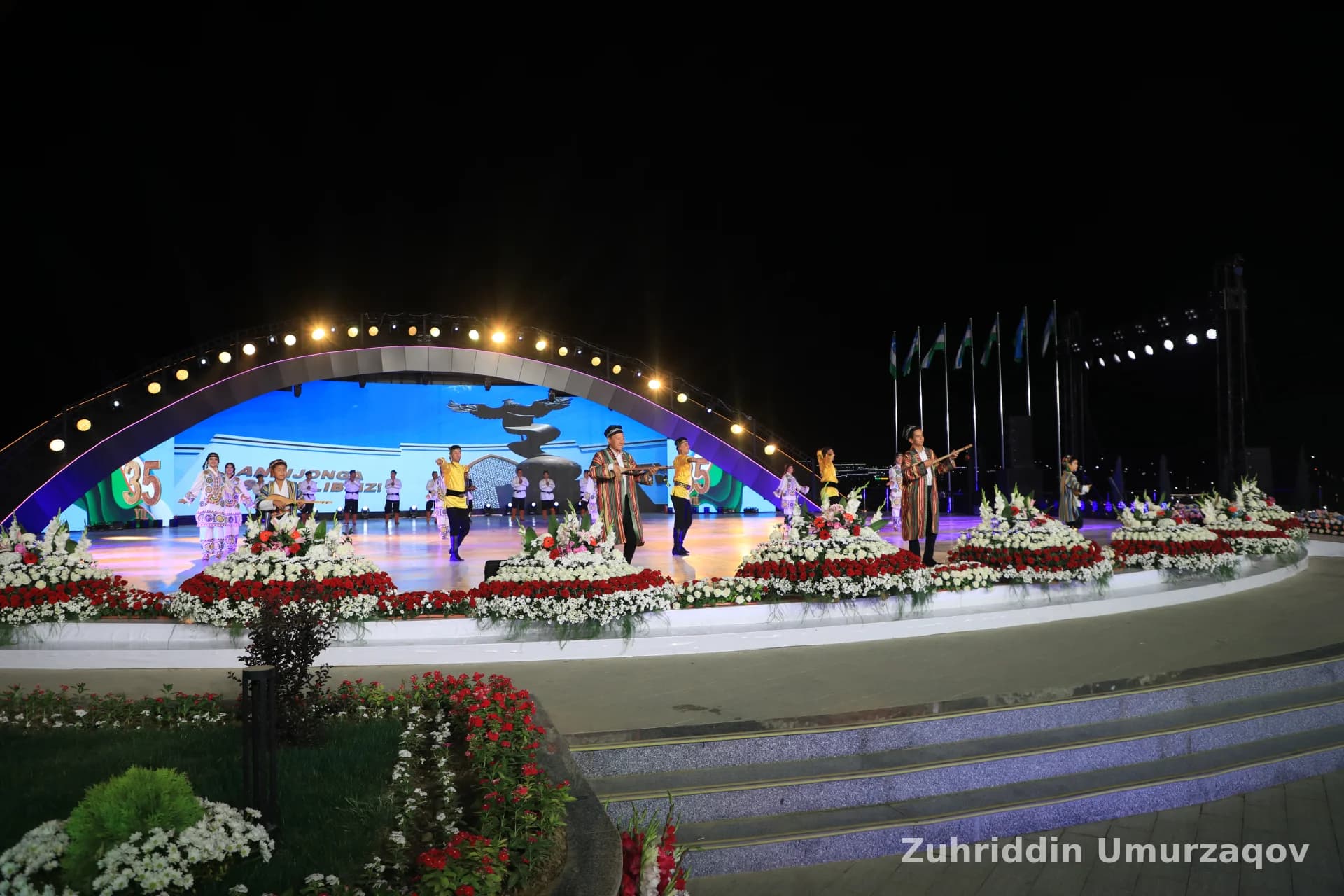 Kechki tadbirda yoritilgan sahnadagi ijrochilar