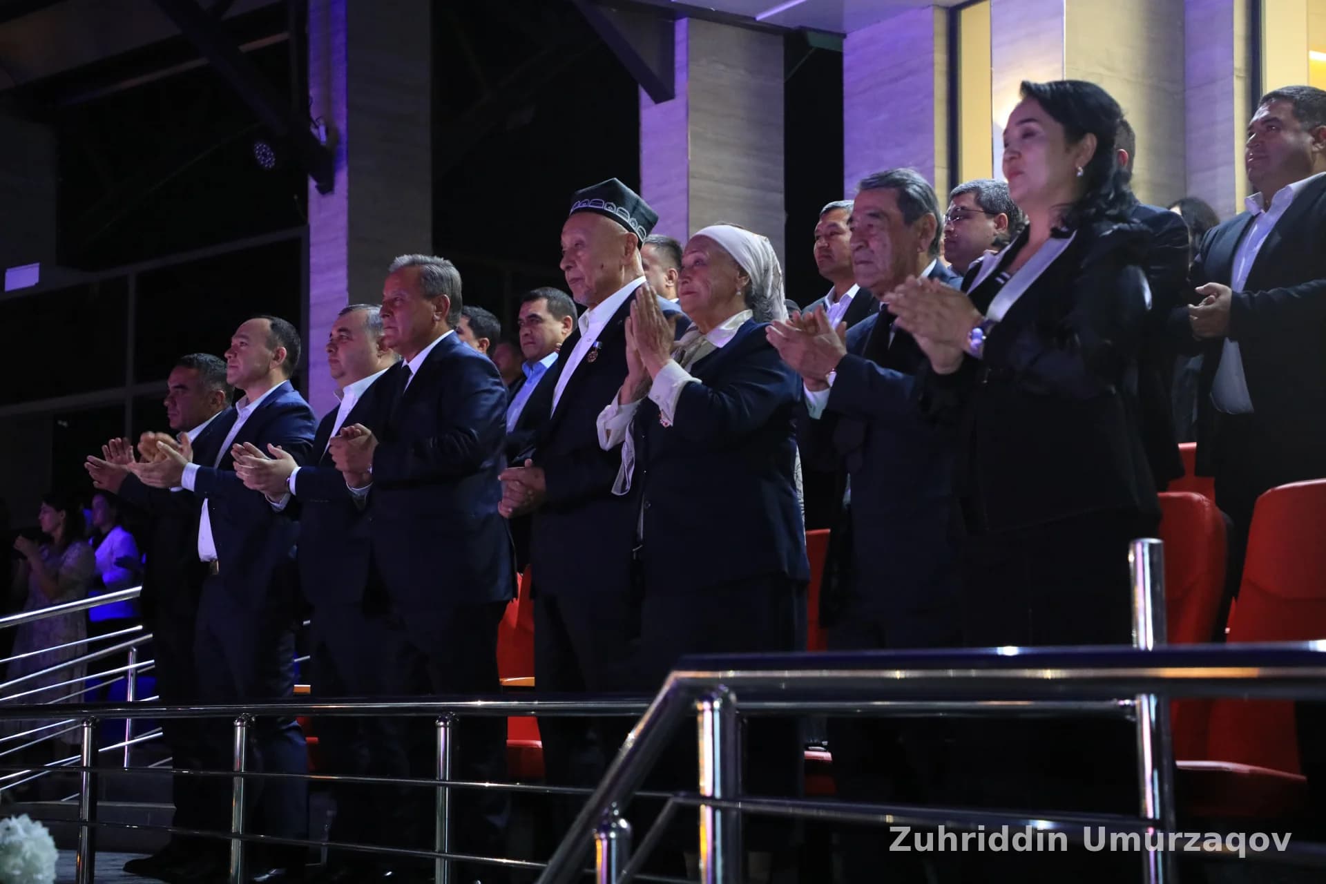 Tomosha zalida turgan va qarsak chalayotgan bir guruh odamlar