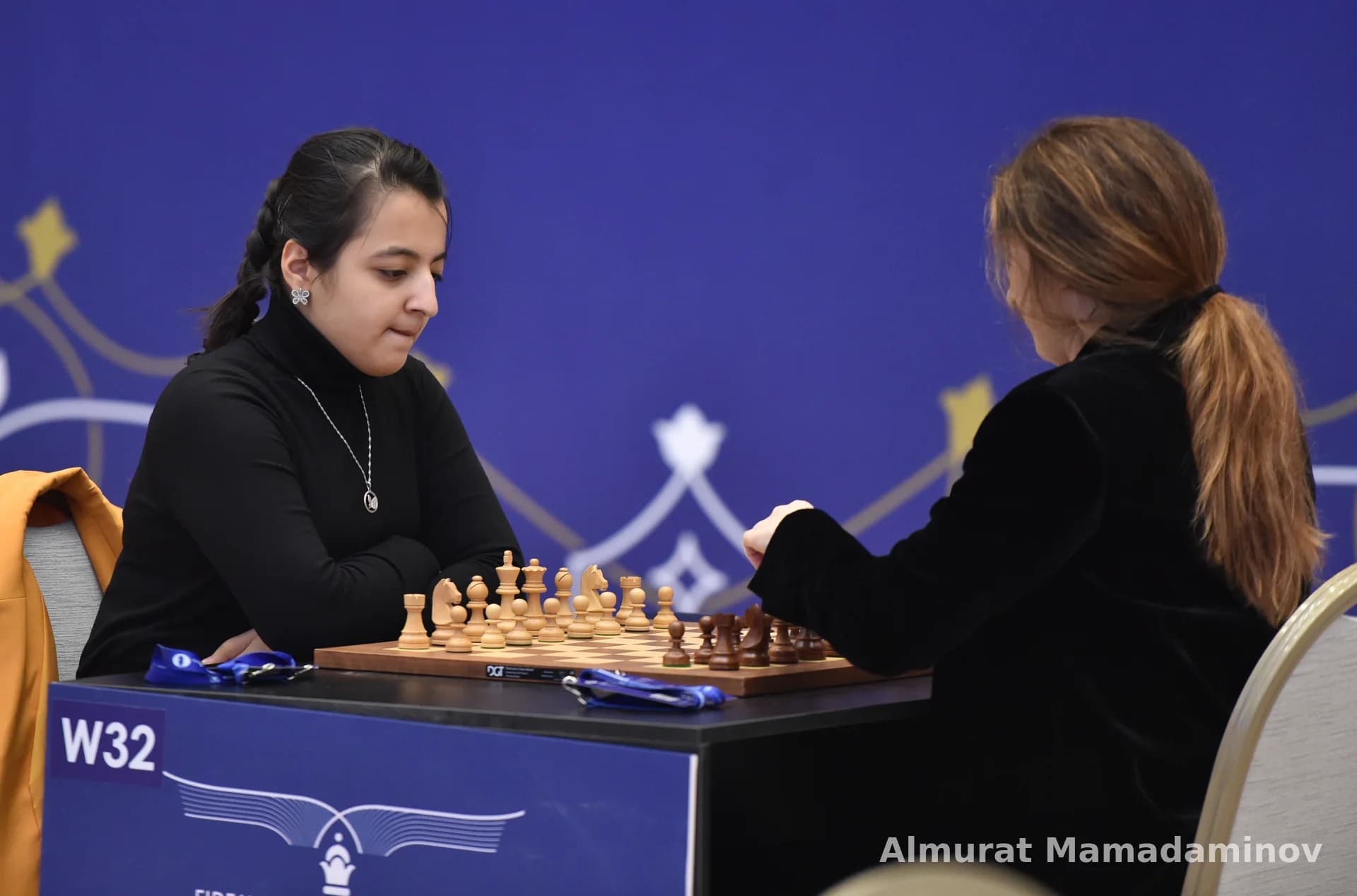 Two women playing a chess match at a table