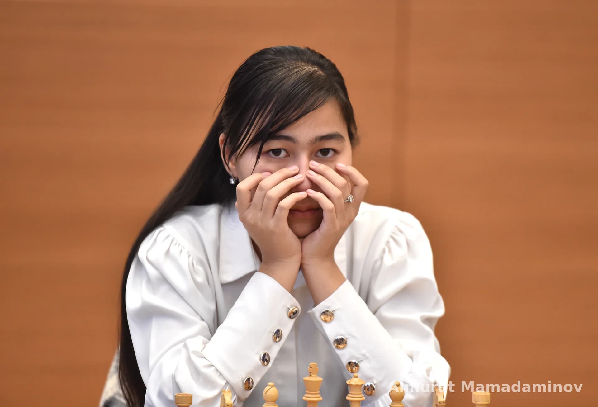 Portrait of a person resting hands on face during chess competition