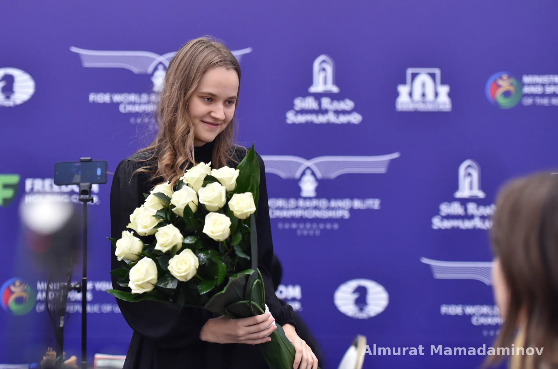 Young person holding a bouquet of white roses