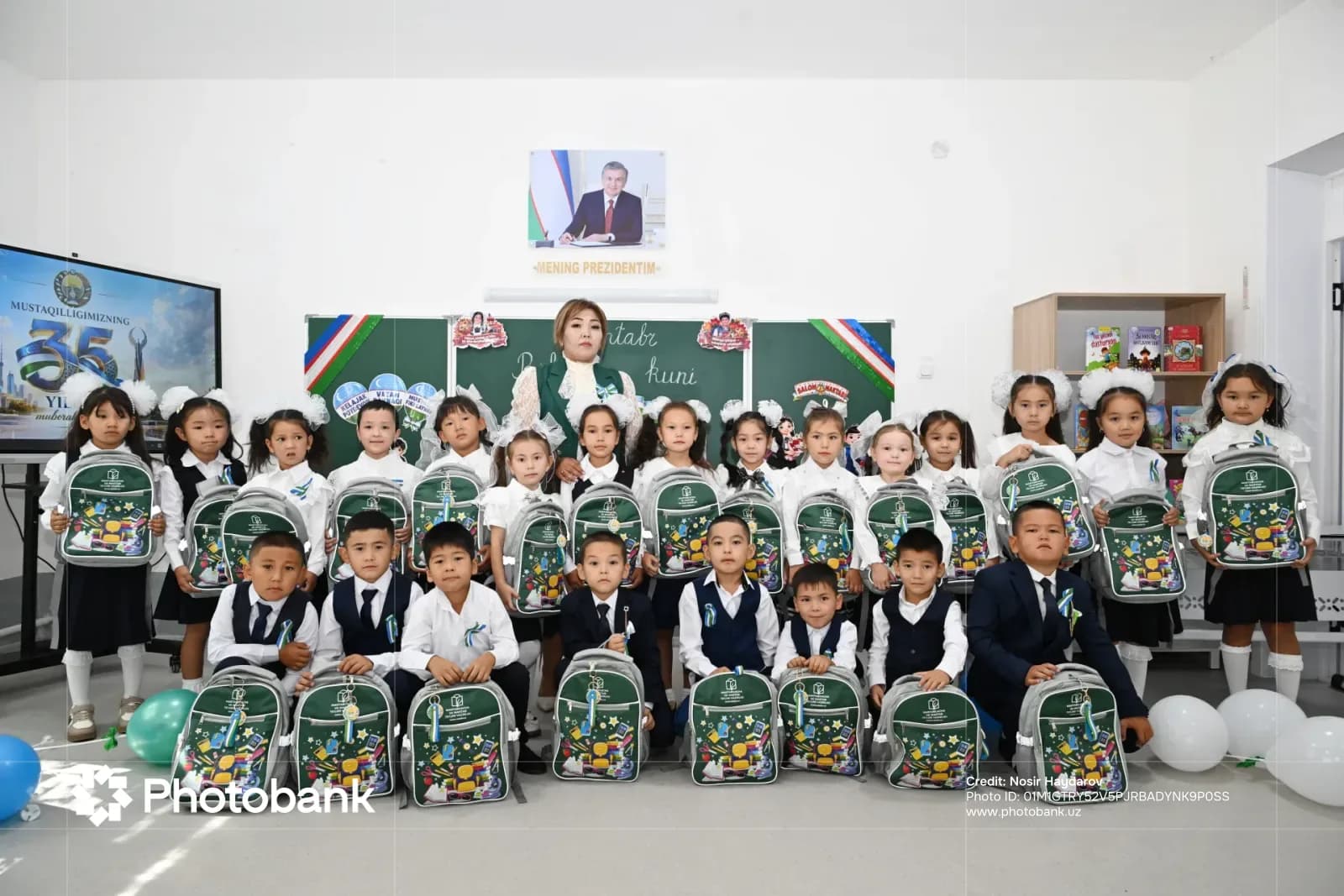 Children holding school backpacks in a classroom