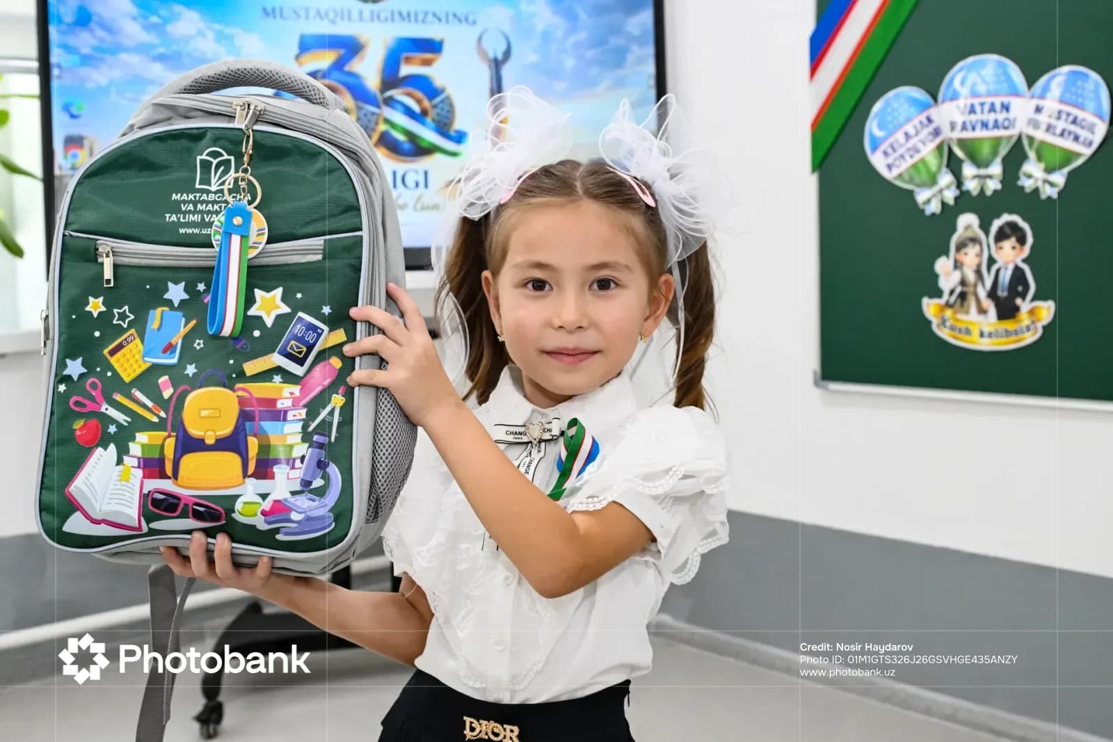 Young girl holding a backpack