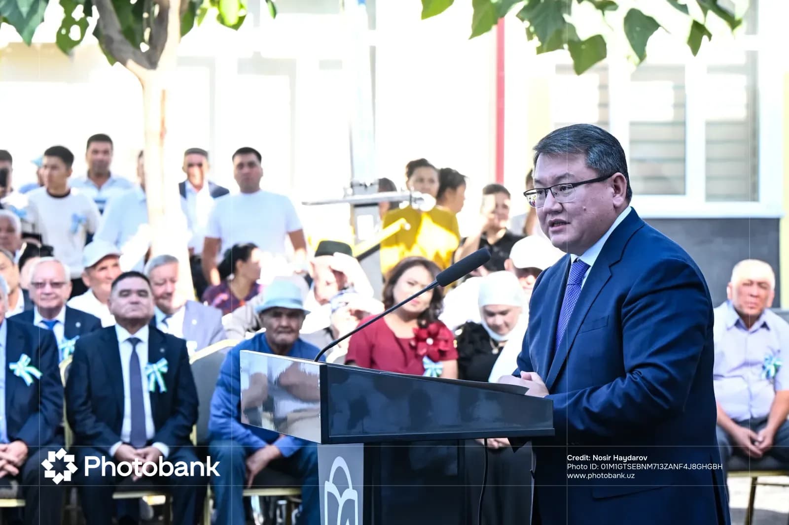 Man speaking at a podium outdoors