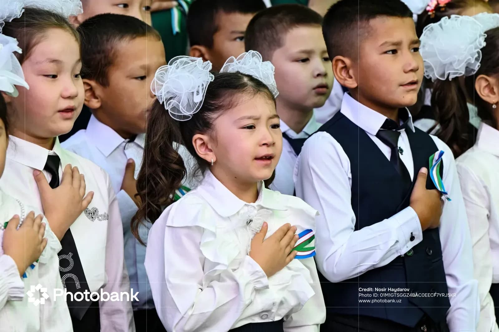 Children standing together with hands on chests