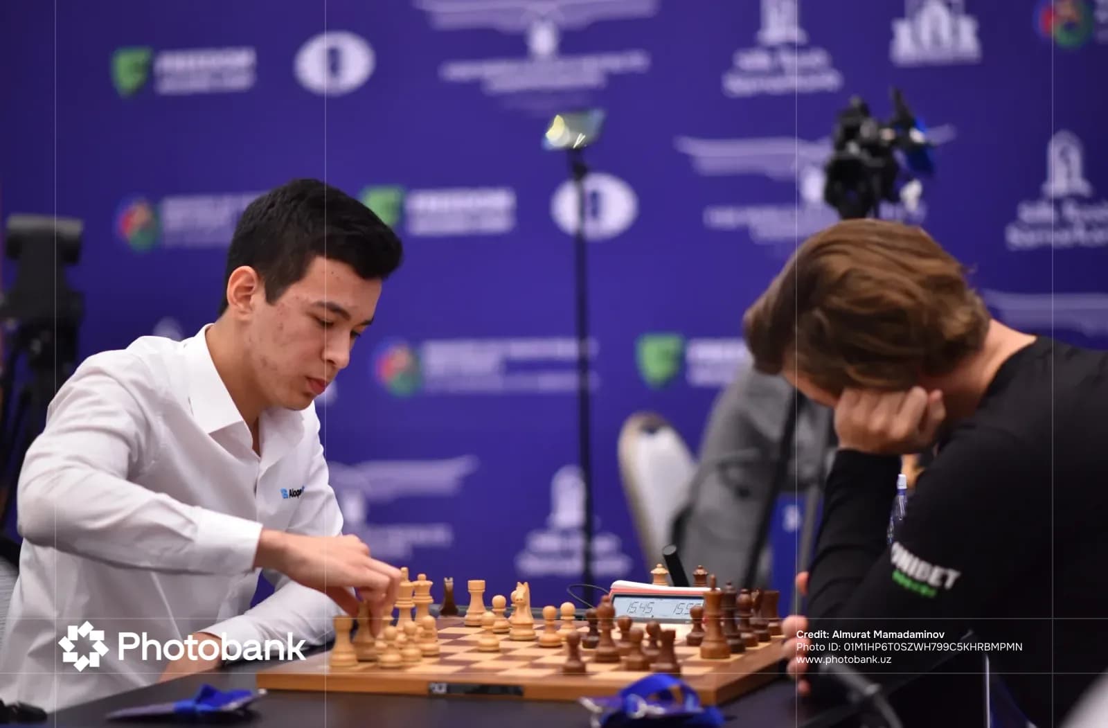 Two competitors play a chess match indoors