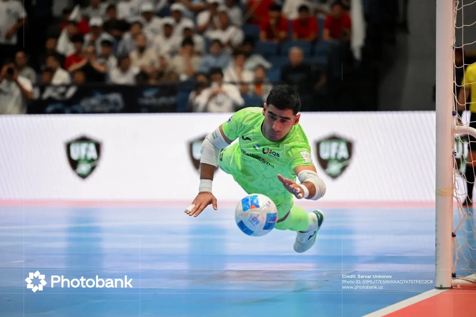 Athlete dives to block a ball during an indoor sports competition