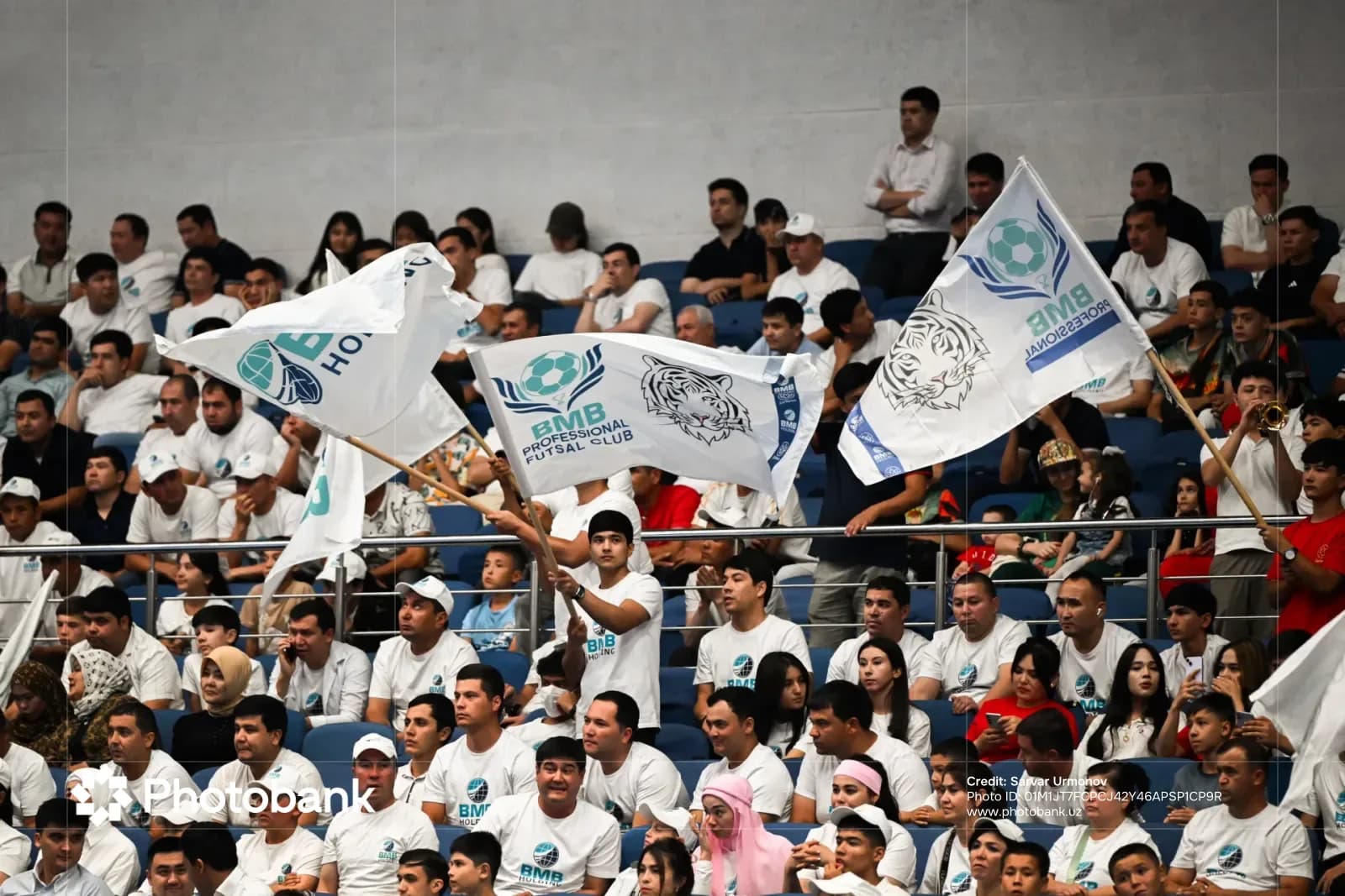 Spectators waving flags in an indoor arena