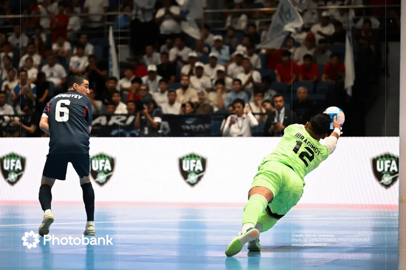 Goalkeeper dives to save a ball during an indoor sports match
