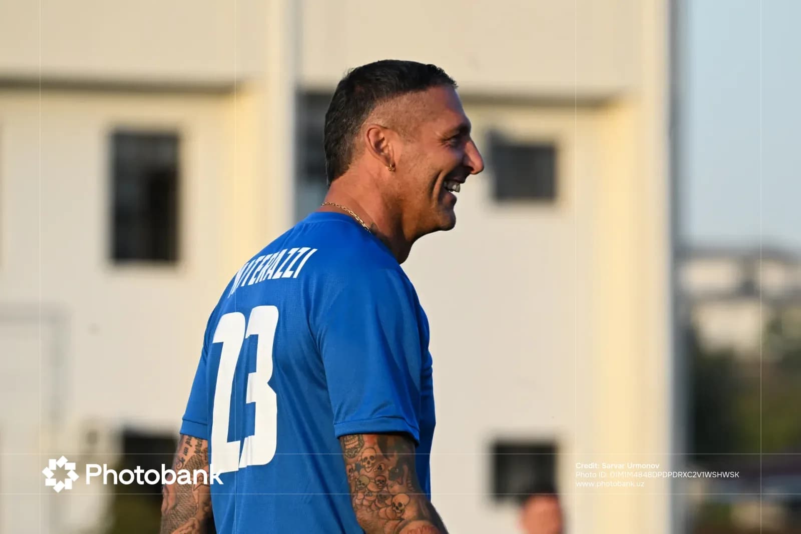 Athlete in blue sports jersey smiling outdoors