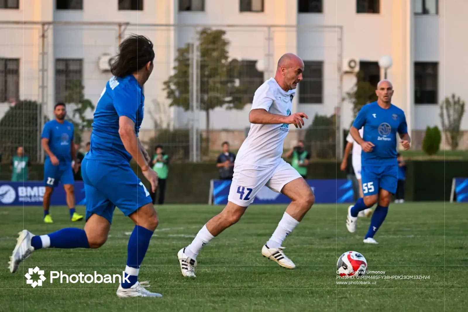 Players competing in a football match on a grass field