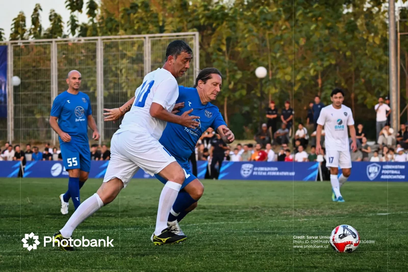 Players competing in a football match on an outdoor field