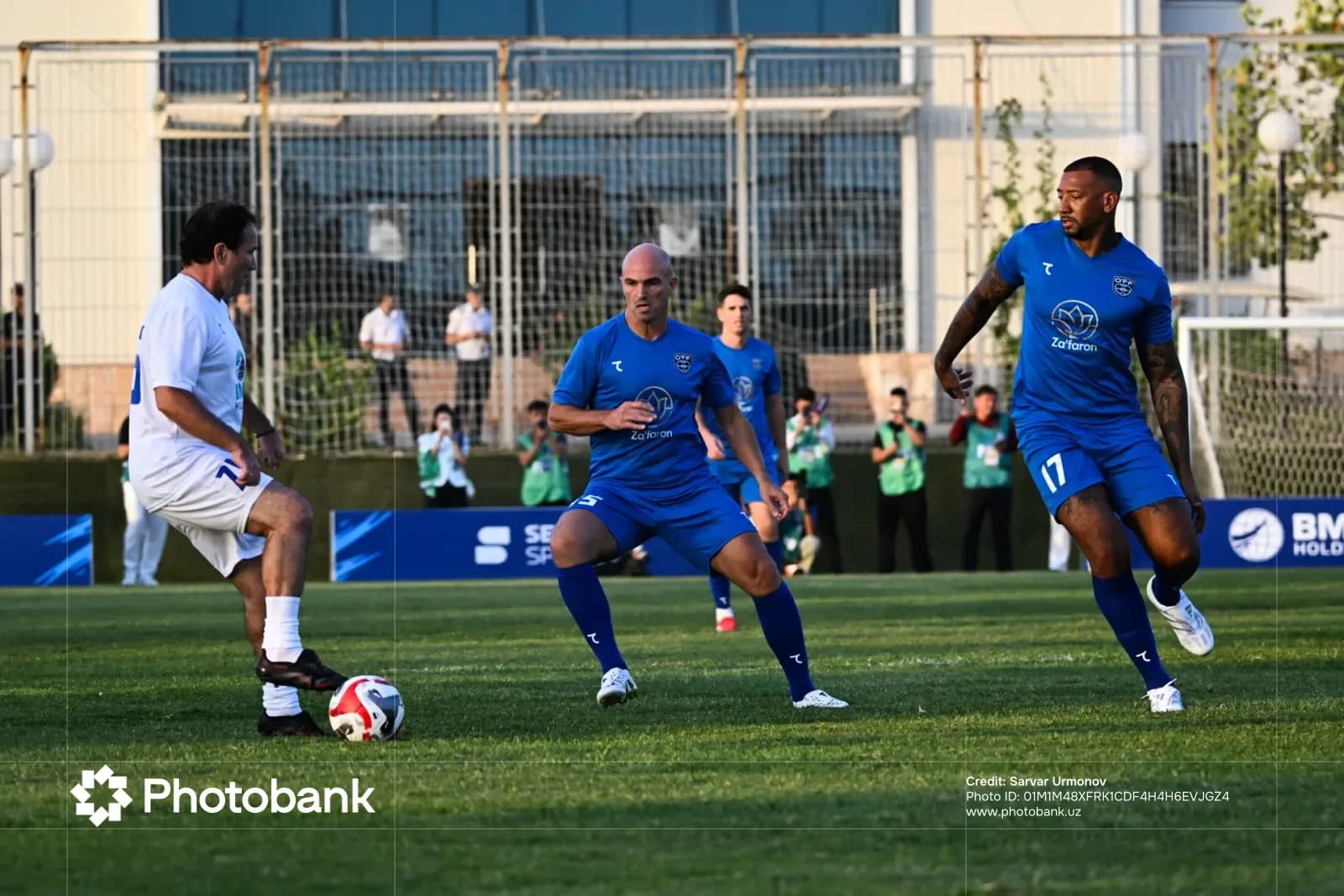 Men playing football on grass pitch