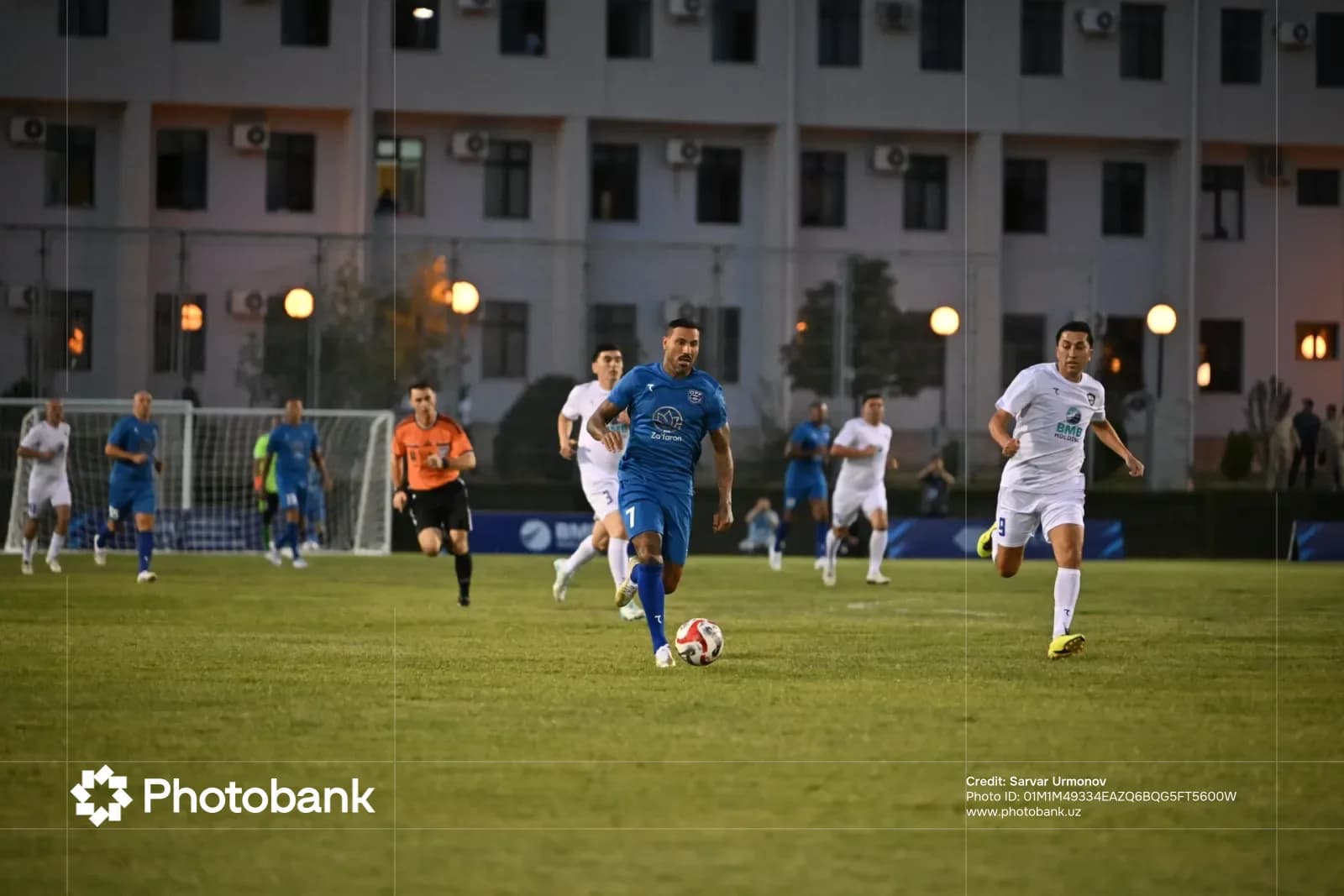 Players competing in a football match on a grass field